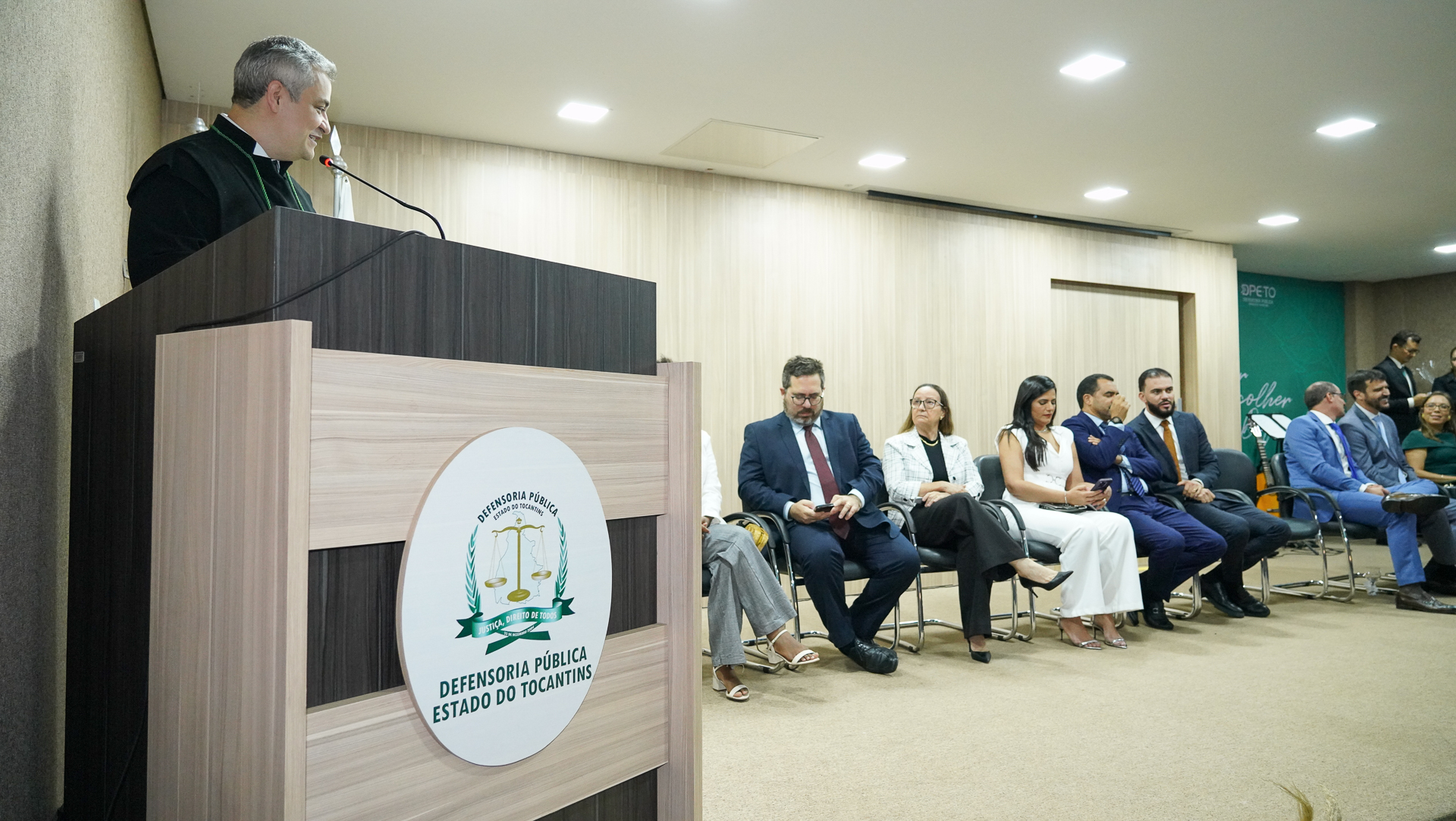 Grupo de oito pessoas, há uma pessoa em pé no púlpito e os demais sentados e atentos ao que o orador diz.