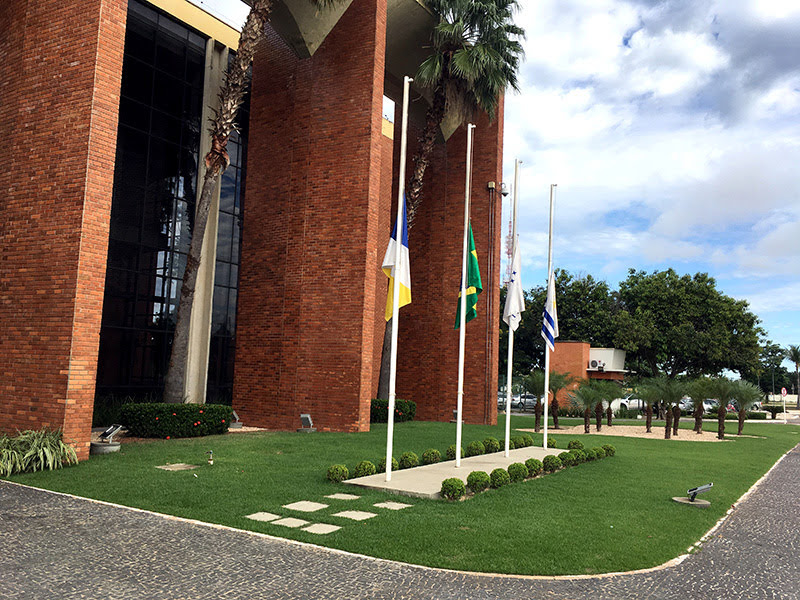 Vista lateral da sede do Tribunal de Justiça do Tocantins, mostrando colunas do Palácio Rio Tocantins na Praça dos Girassois, com parte da calçada e mastros de bandeira