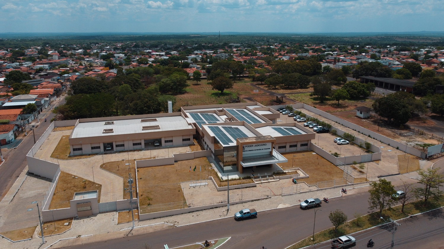 Vista áera da sede do Fórum de Paraíso, mostrando o prédio cercado por jardim, estacionamento e paredes de vidro espelhado