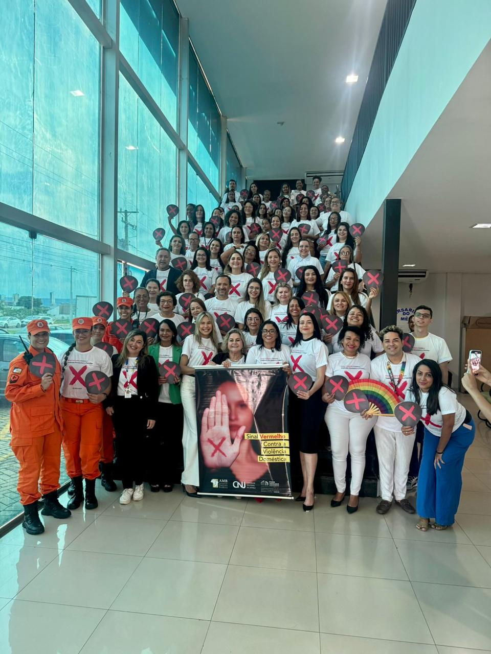 Mulheres posam em escada após lançamento da Campanha Sinal Vermelho Contra a Violência Doméstica”