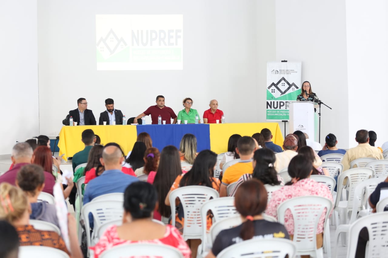Desembargadora Maysa Vendramini usando uma blusa estampada e calça verde clara discursa durante entrega de títulos de legitimação fundiária